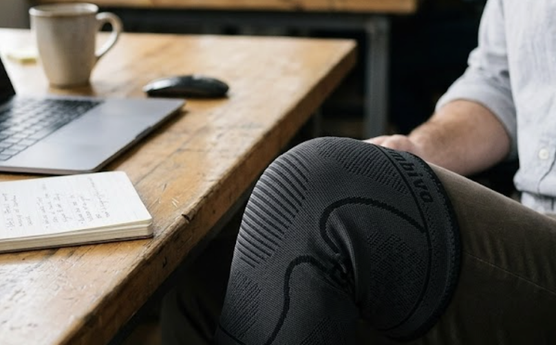 knéo brace gedragen achter het bureau